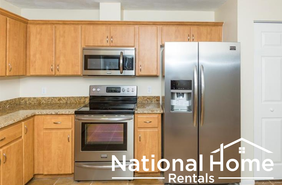 a kitchen with wooden cabinets and a stainless steel refrigerator