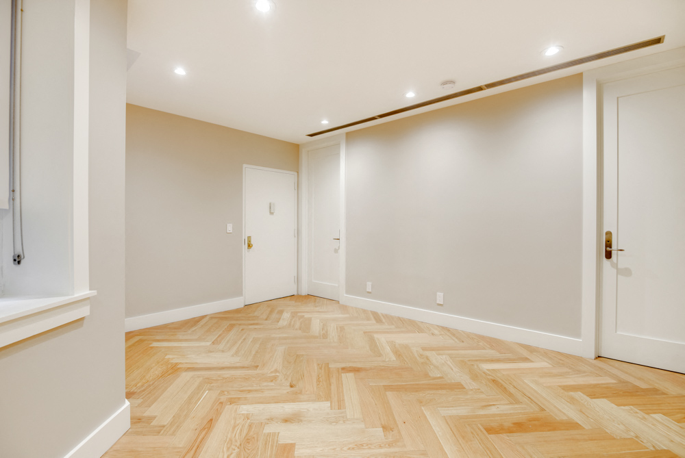 a living room with a wooden floor and white walls