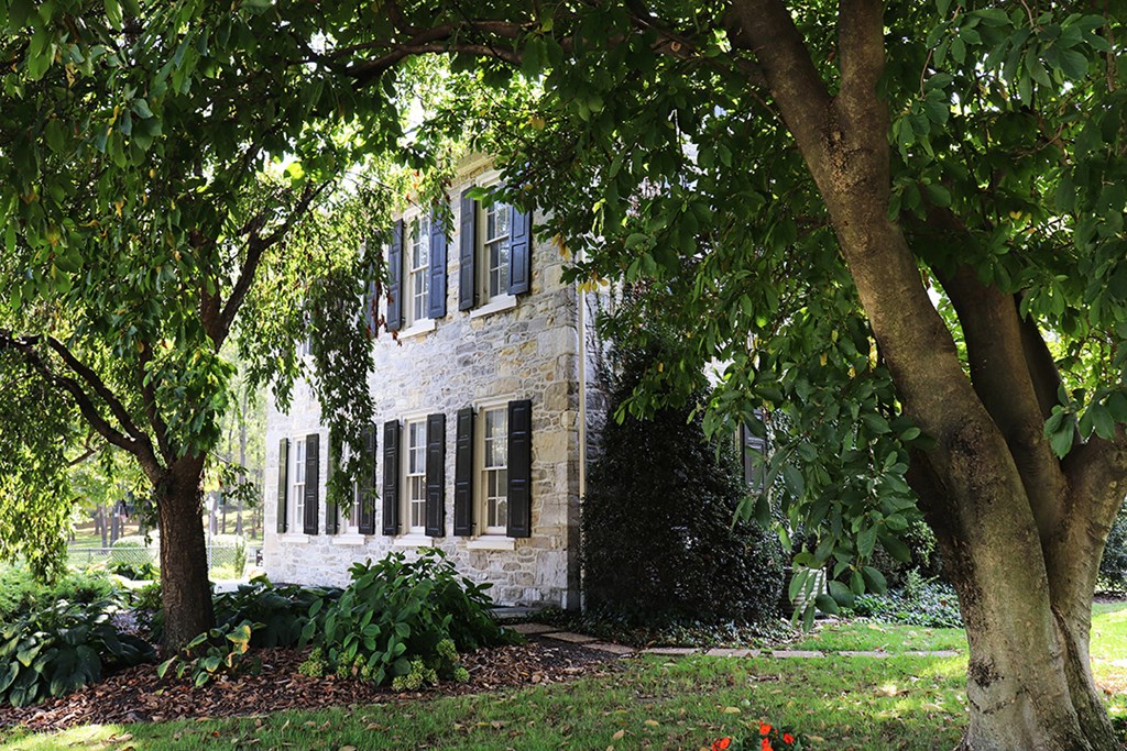 a stone house with trees in front of it