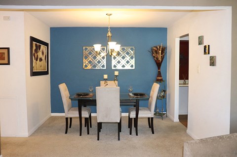 a dining room with a table and chairs and a blue wall