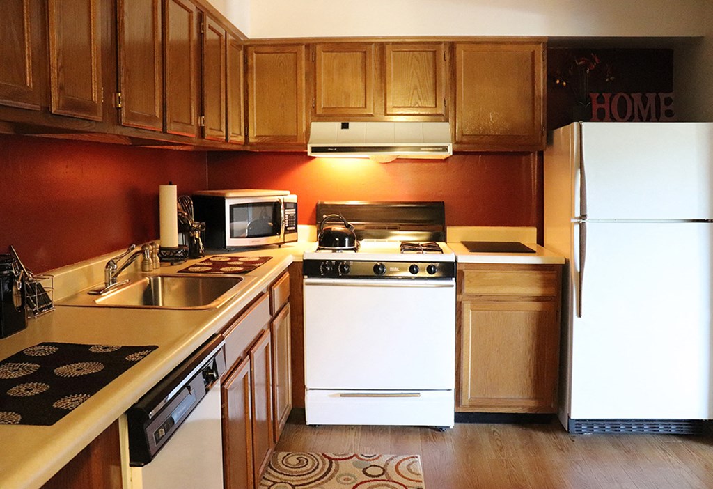 a kitchen with white appliances and wooden cabinets