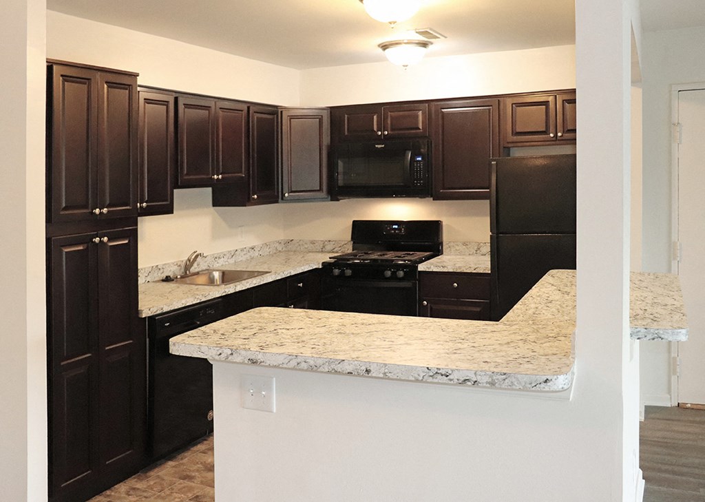 a kitchen with black appliances and granite counter tops