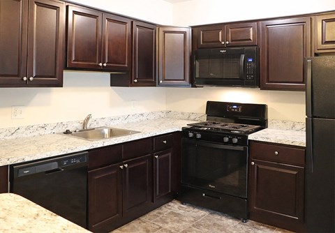 a kitchen with black appliances and granite counter tops