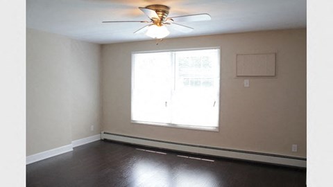 a empty room with a ceiling fan and a window