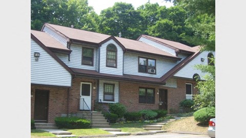 a house with a brown roof and white siding