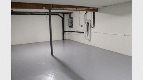 an empty garage with a pole and wires on the wall
