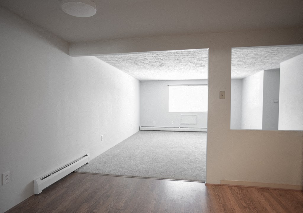 an empty room with white walls and wooden floors
