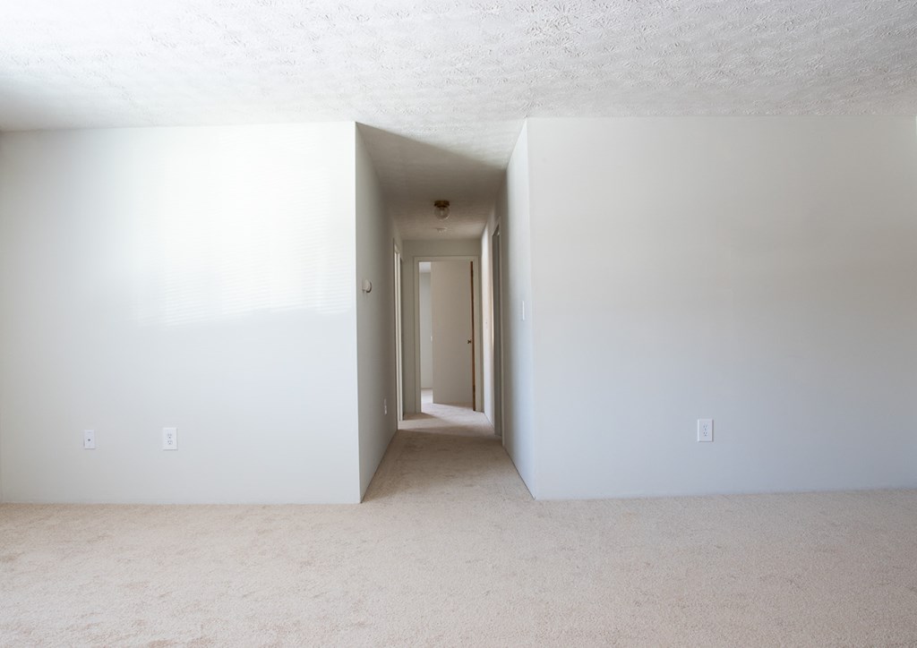 an empty room with white walls and a door to a hallway