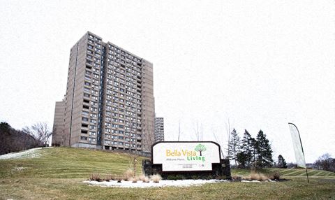 a tall building on a hill next to a sign