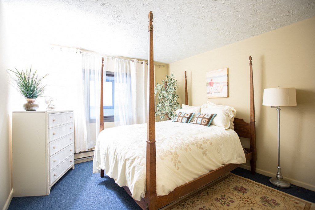 a bedroom with a bed and a dresser and a window