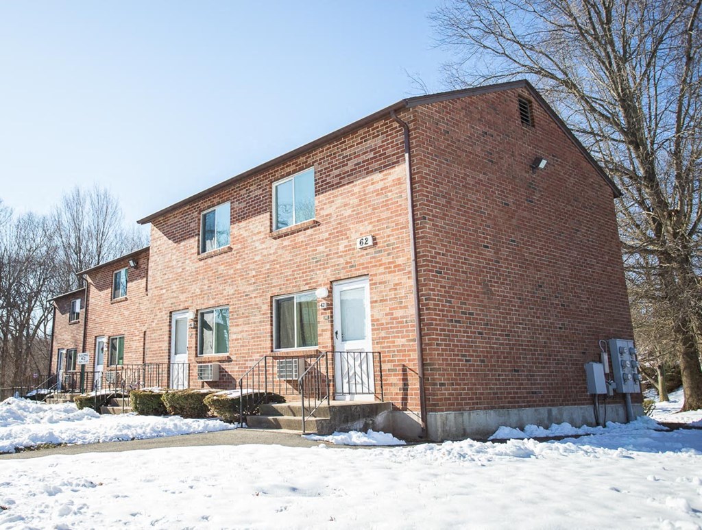 the front of a brick house in the snow