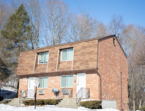 the front of a brick house in the snow