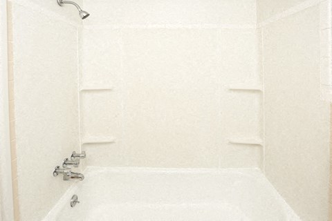a white bathroom with a shower and a tub