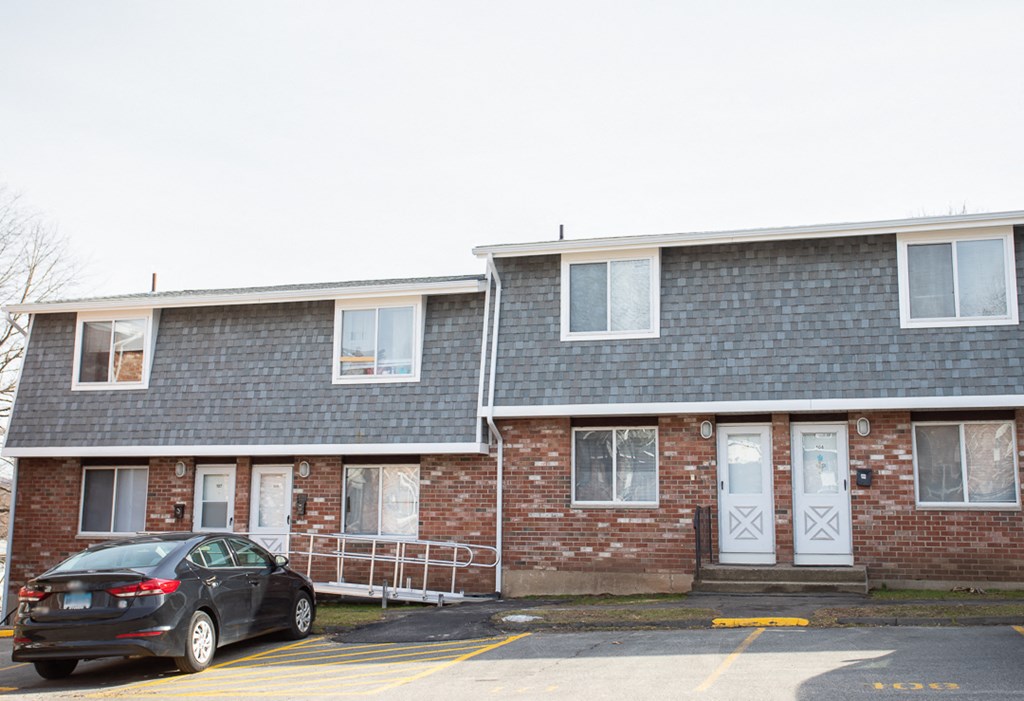 a car parked in front of a brick apartment building