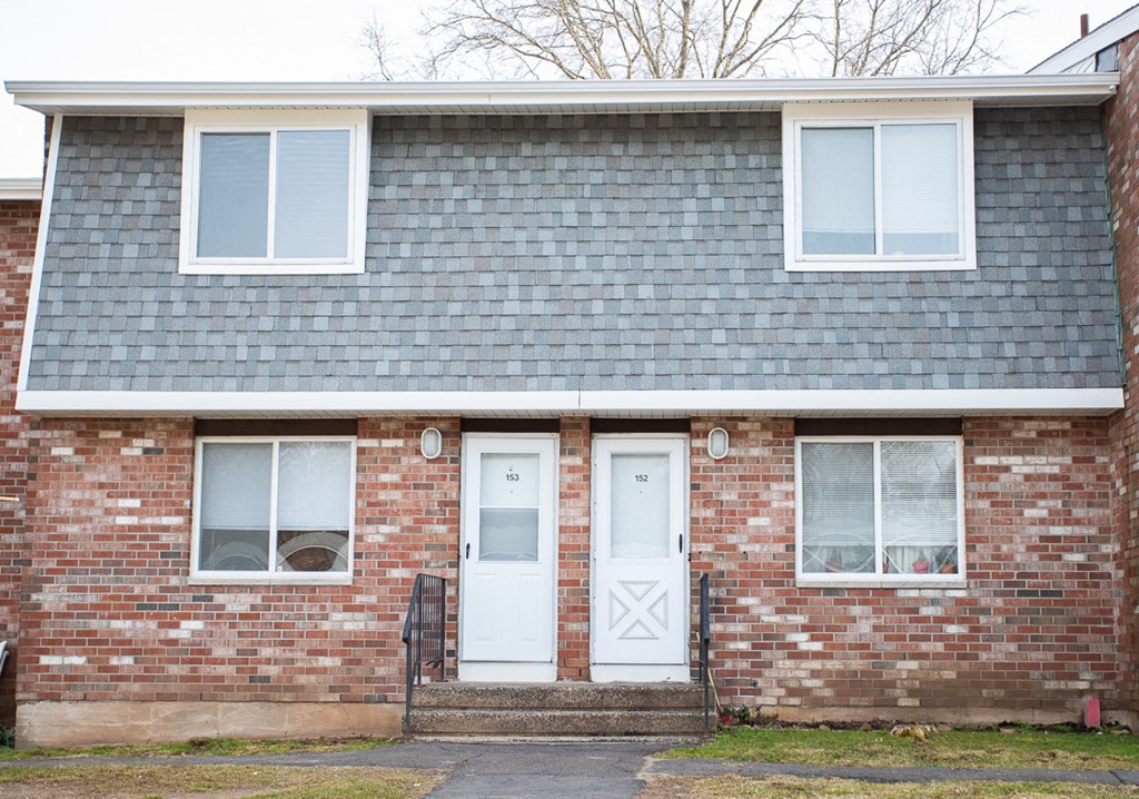 the front of a brick house with two doors