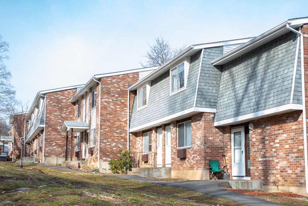 a row of brick apartment buildings with blue roofs