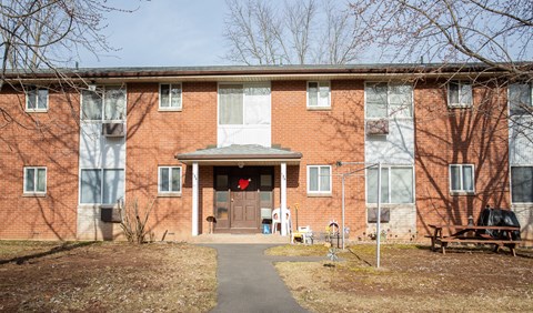 the front of a brick building with a sidewalk in front of it