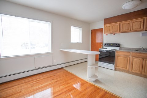 an empty kitchen with a white table in the middle
