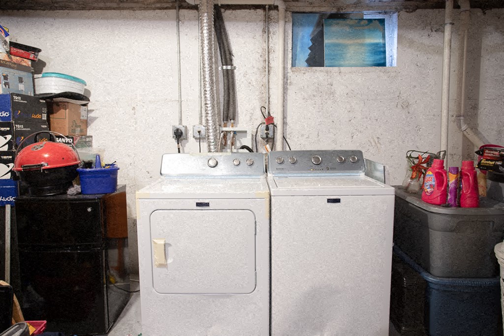 two washing machines in a room with a sink and a window