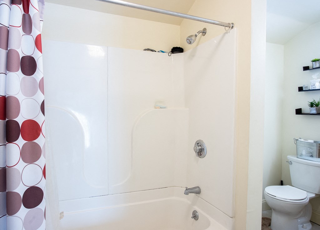 a bathroom with a shower and a toilet and a shower curtain