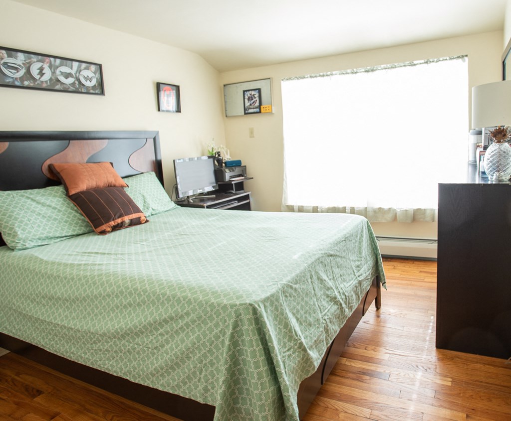 a bedroom with a bed and a dresser and a window