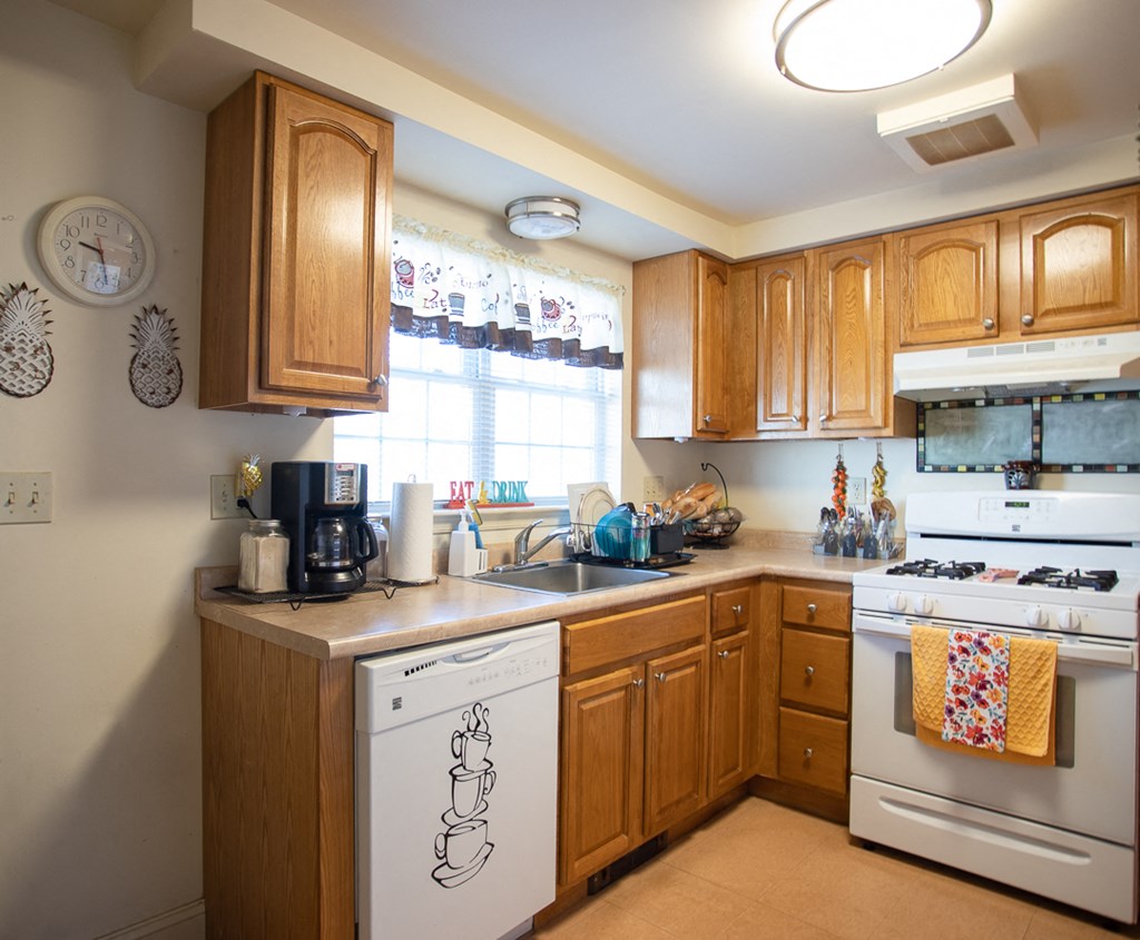 a kitchen with white appliances and wooden cabinets