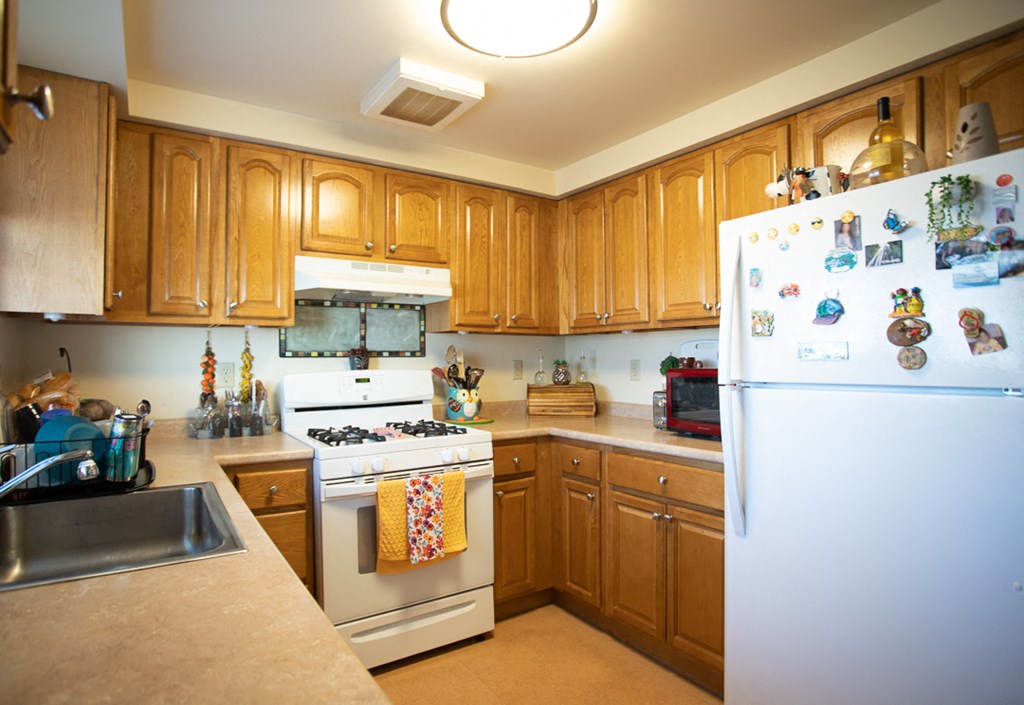 a kitchen with white appliances and wooden cabinets