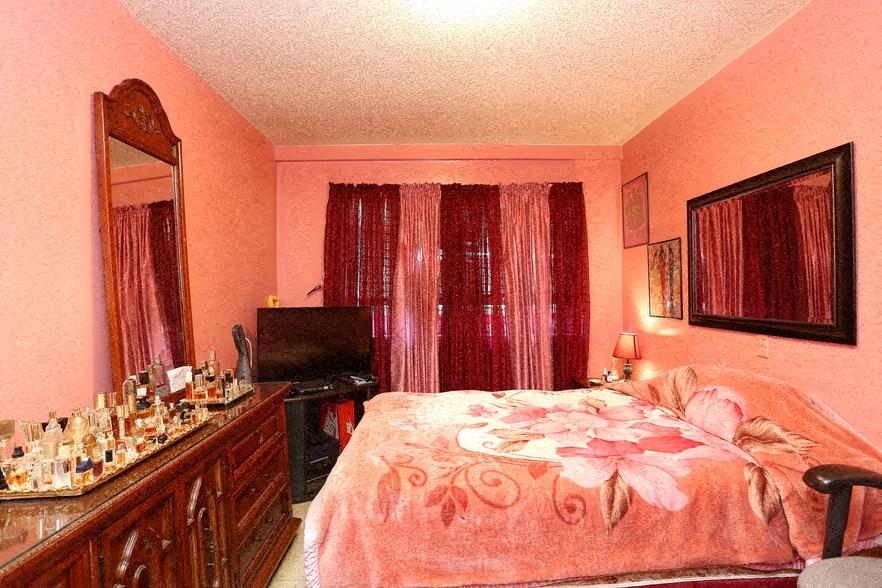 a bedroom with a bed and a dresser and a mirror