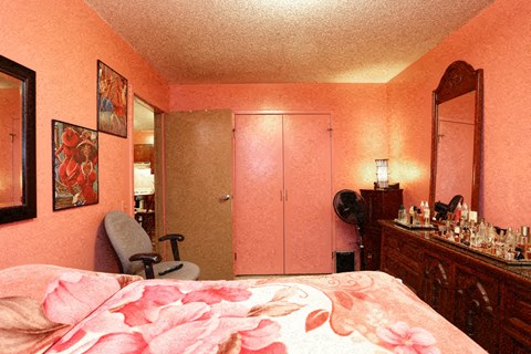 a bedroom with a bed and a chair and a mirror