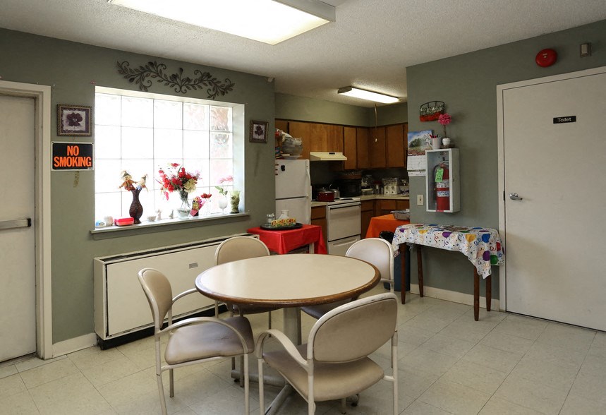 a kitchen with a table and chairs in front of a window