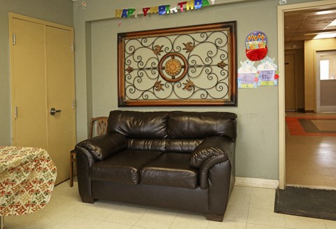 a living room with a leather couch and a decoration on the wall