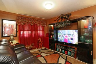 a living room with a leather couch and a tv