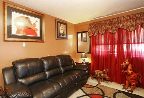 a living room with a leather couch and rocking horses