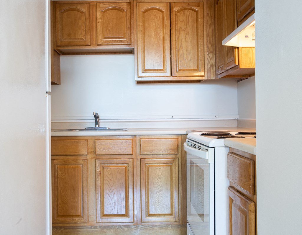 a kitchen with wooden cabinets and a stove and a sink