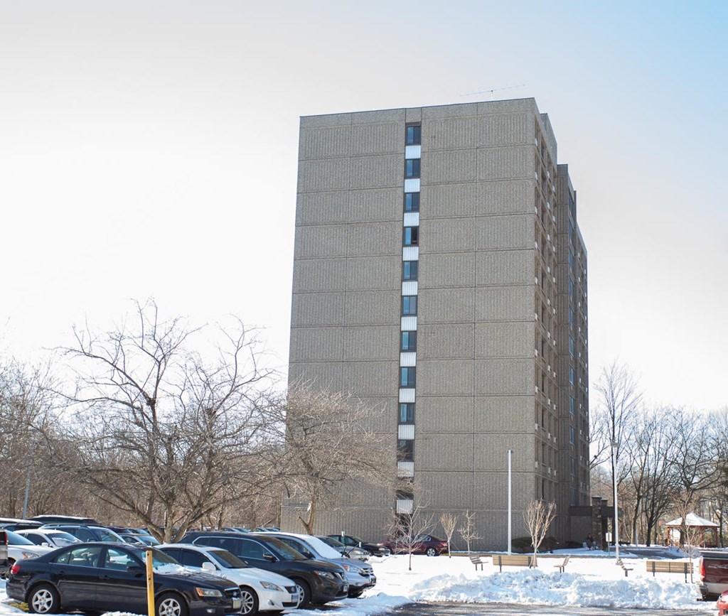 a tall building with cars parked in a parking lot