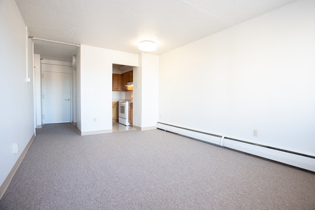 an empty living room with white walls and carpet