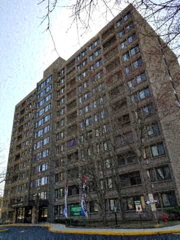a tall apartment building with a street in front of it
