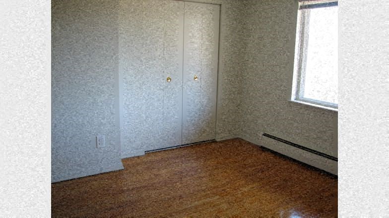 a small room with a wooden floor and a window