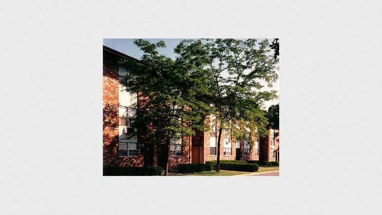 a brick building with trees in front of it