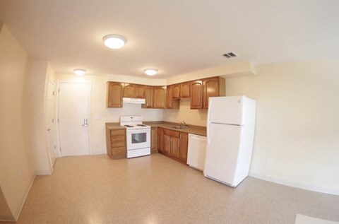 an empty kitchen with a refrigerator and a stove