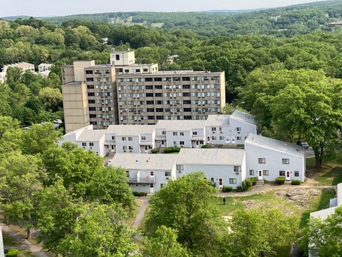 A large white building with a smaller brown building behind it.