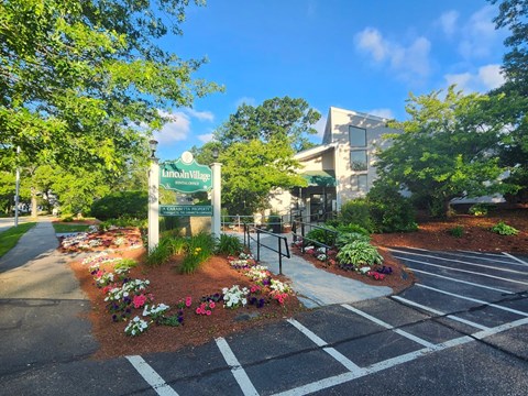 A sign that says "Lancaud Village" is in front of a building.