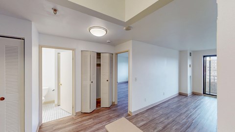 A spacious room with wooden floors and white walls.