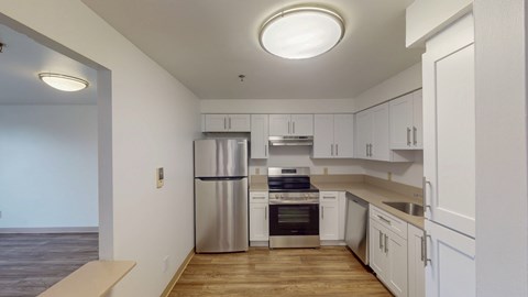 A kitchen with white cabinets and stainless steel appliances.
