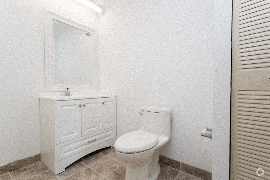 a white bathroom with a toilet and a sink