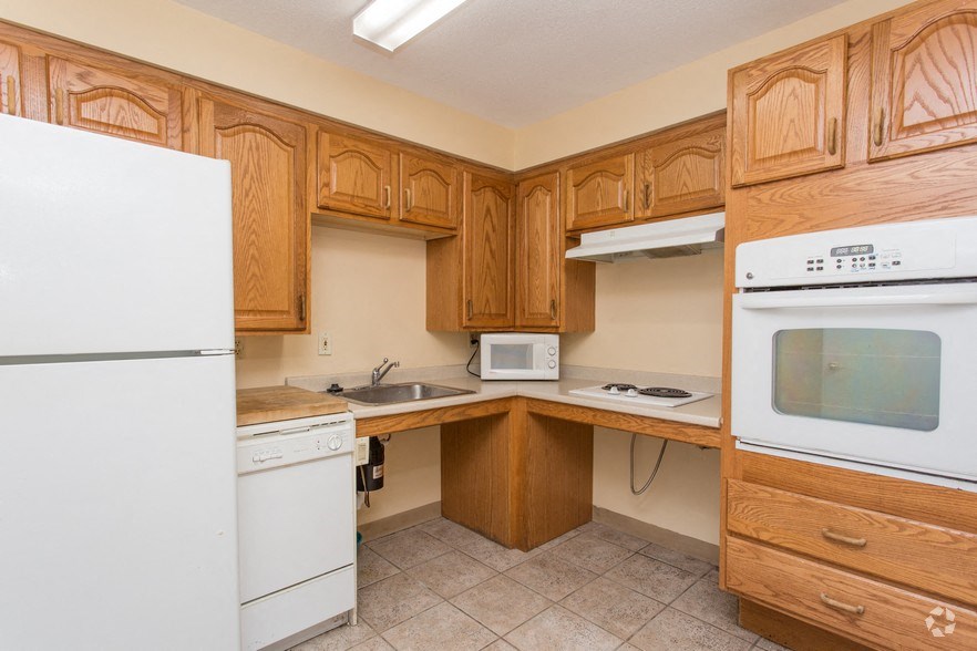 a kitchen with wooden cabinets and a white stove and refrigerator