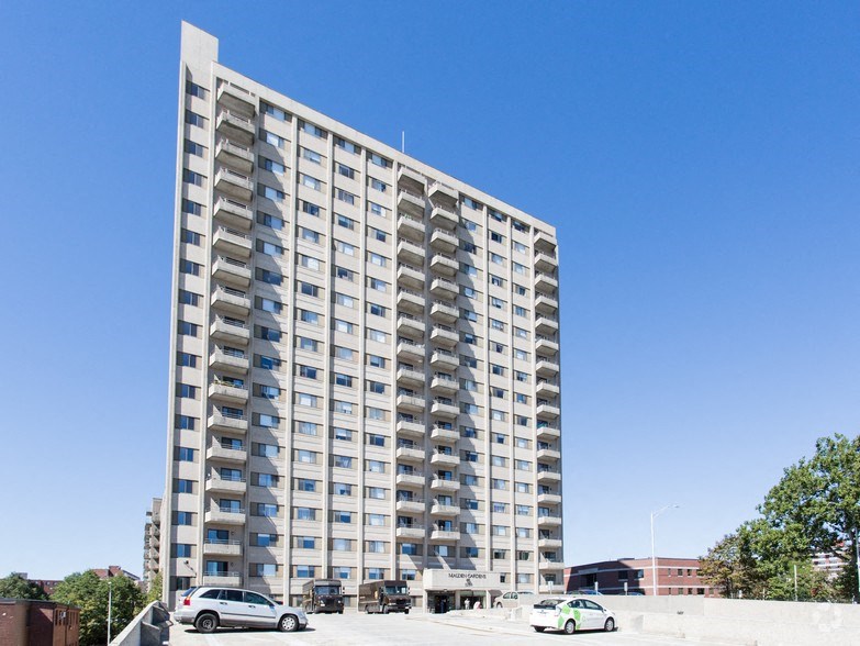 a tall apartment building with cars parked in front of it