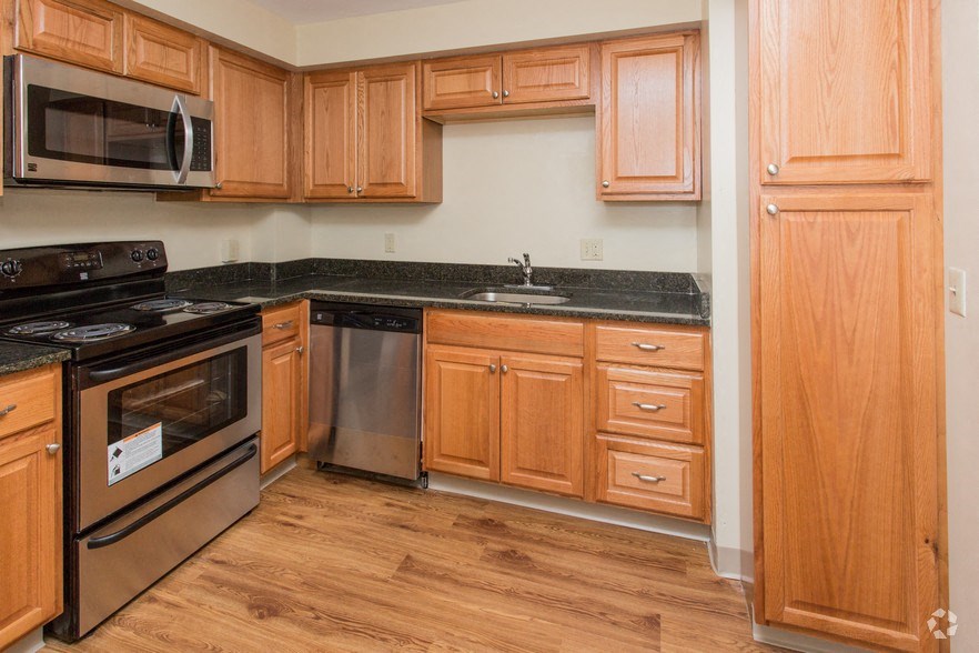 a kitchen with wooden cabinets and stainless steel appliances