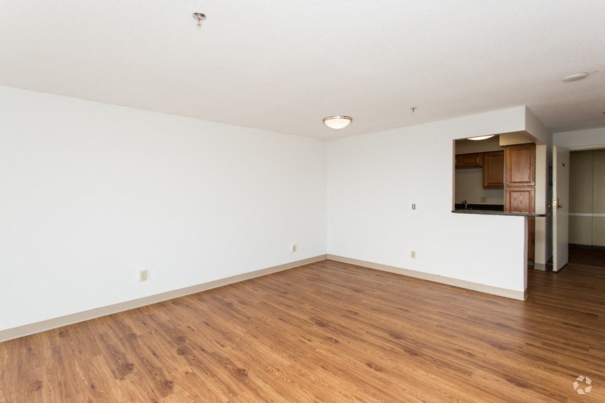 an empty living room with wood flooring and white walls