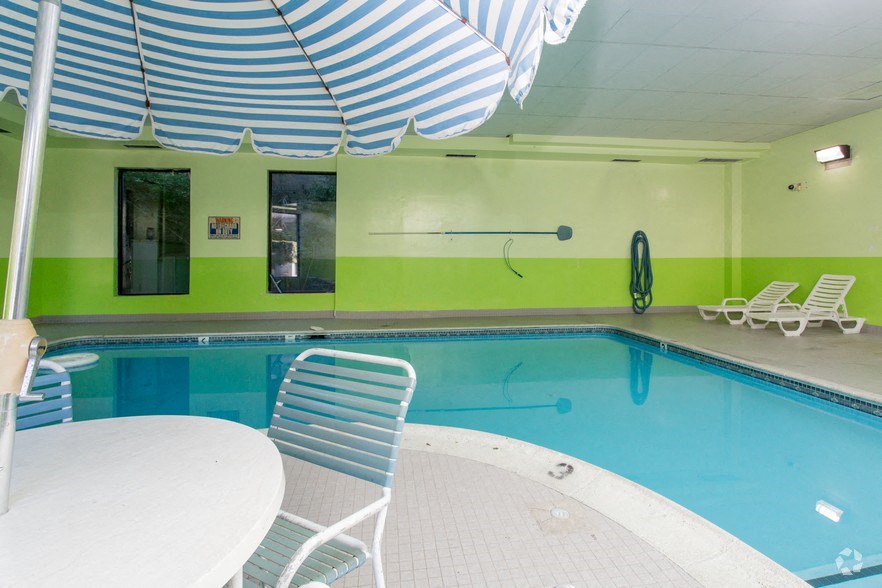 a swimming pool with chairs and an umbrella